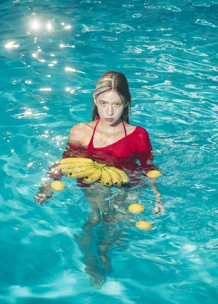 Femme se détendre dans la piscine spa. Vacances d'été et voyage à l'océan. Vitamine dans la banane chez la fille assise près de l'eau. Régime alimentaire et des aliments biologiques sains, végétariens. femme aux fruits tropicaux dans la piscine . — Photo