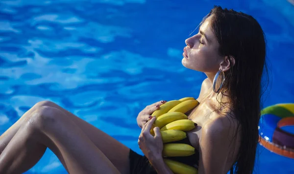 Trópusi gyümölcs medencében nő. -Vitamin a banán, a lány ül a víz közelében. Nyaralás és utazás óceán. Fogyókúra és egészséges bio ételek, vegetáriánus. Nő lazíthatnak a gyógyvizes medence. — Stock Fotó