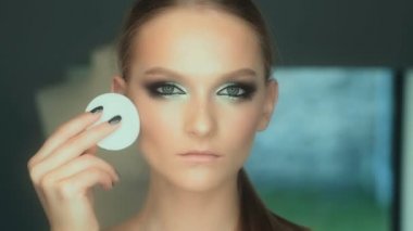 Makyaj sanatçısı için çekici bir genç kadın makyaj uygulamak. Makyaj genç kız için. Genç kız Güzellik Salonu.