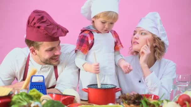 調理キッチン食品の Fogetherness コンセプトが家族 一緒にキッチンで食事を調理している家族 かわいい男の子と野菜を切り 自宅のキッチンで料理をしながら笑みを浮かべて彼のハンサムなお父さん — ストック動画