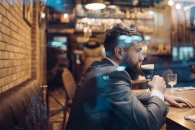 Sakallı adam diğer restoranında bira cam. Uzun sakal içki puro kulübü ile iş adamı. Bira zamanı. ciddi bar müşteri oturup bira içerken kafede. Barda bekleyen hipster tarihi toplantısı.