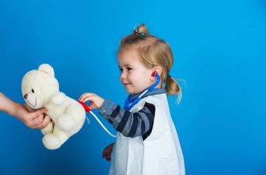 Mutlu bir çocukluk veteriner Doktor stetoskop ile oyuncak hayvan incelemek