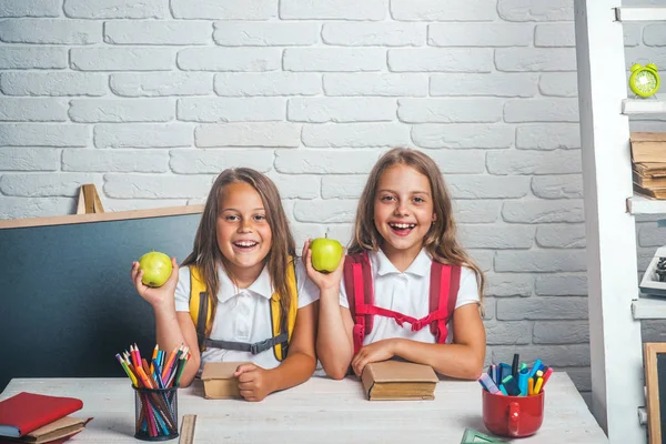 학교 및 홈 스 쿨링 돌아가기. 기술에 교실에서 작은 자매 우정 어린 소녀는 점심 시간에 사과 먹는다. 여자의 학교 시간입니다. 9 월 1 일에 수업에서 아이 들 행복 학교 — 스톡 사진