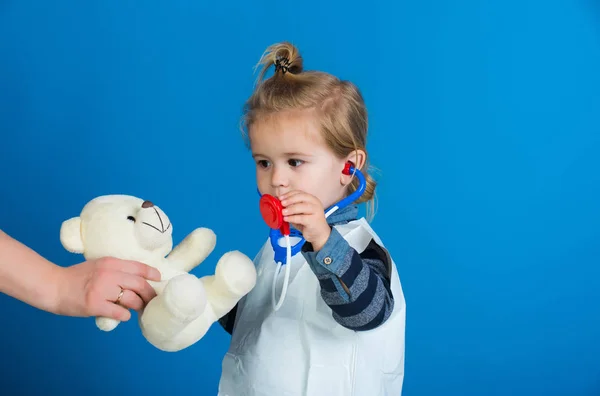 Barn spela veterinär med Nalle i mödrar hand — Stockfoto