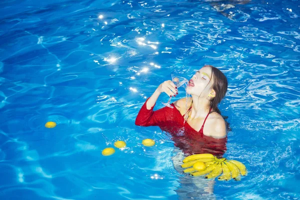 Vrouw ontspannen in het spa-bad. vrouw met tropische vruchten in zwembad. Vitamine in bananenbladeren op meisje zit in de buurt van water. Op dieet zijn en gezond biologisch voedsel, vegetarisch. Zomervakantie en reizen naar de Oceaan. — Stockfoto