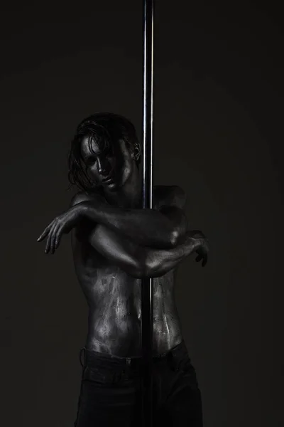 Ο άνθρωπος με τον γυμνό κορμό που καλύπτεται με ασημί χρώμα, μαύρο φόντο. — Φωτογραφία Αρχείου