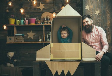 Roket fırlatma kavramı. Çocuk mutlu oturmak karton el roket yapımı. Baba, baba, küçük kozmonot ile çocuk oyun karton kutudan yapılan roket oturup. Çocuk şirin çocuk oyun kozmonot, astronot.