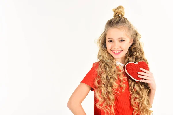 beautiful school age girl wearing red holding heart