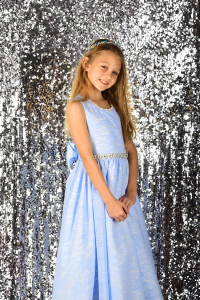 青いドレスの長い髪を持つカメラで笑顔のかわいい女の子 — ストック写真