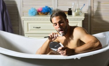 Sakallı adam banyoda jiletle tıraş oluyor. Sakalında sabun olan sakallı adam aynaya bak..