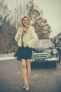Kadın yolda yürür. Çift Romantik tarihte aşık. Retro koleksiyonu araba ve otomatik mekanik sürücü tarafından onarın. Sakallı adam ve kürk manto seksi kadın. Seyahat ve iş gezisi ya da aksaklık hiking