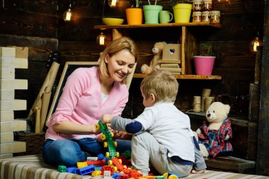 Anne ve çocuk Oluşturucu, plastik tuğla ayrıntıları ile oynamak. Kreş kara tahta arka plan ile. Annelik kavramı. Evde Oluşturucu ile aile oynamak. Anne ve oğlu Oluşturucu ile oynamak.