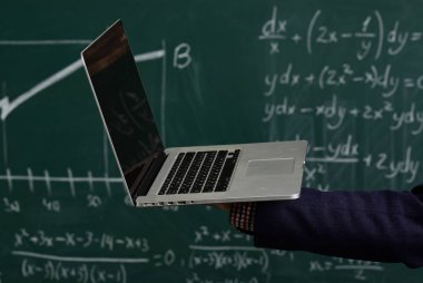 Öğretmen öğrenci yapı özgüven yardımcı olur. Modern öğretmen hippi matematik formülü ile büyük yazı tahtası üzerinde yazılı. Öğrenciler düzenli olarak öğretmen ile iletişim.