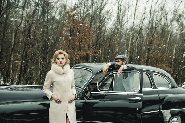 Retro raccolta auto e riparazione auto da parte del macchinista. Coppia innamorata ad un appuntamento romantico. Uomo barbuto e donna sexy in cappotto. Viaggi e viaggi d'affari o autostop. Escort di ragazza di sicurezza . — Foto Stock