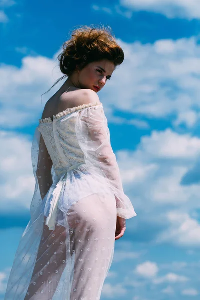 woman in a white dress on the blue sky background