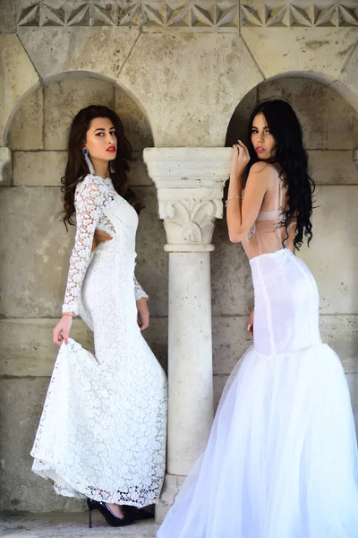 婚礼时装和美容院 两个漂亮的女人在专栏婚纱礼服 — 图库照片