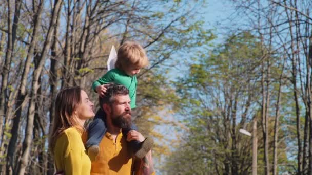 採用された男の子と幸せなカップル 親子関係 養子縁組 人コンセプト 幸せな母 公園の父 若い家族は屋外で採用された少年と — ストック動画
