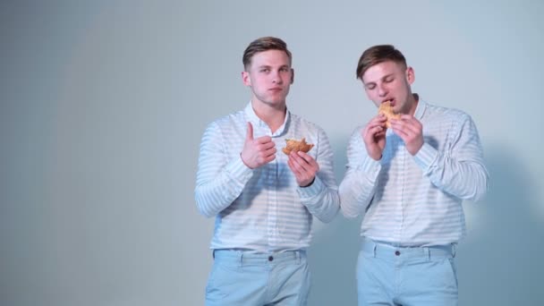 ハンバーガーを食べて幸せな男 ブラザーズのハンバーガーを食べるします 双子のハンバーガーを食べるします 友人は ハンバーガーを楽しんで — ストック動画