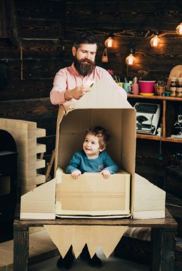 Çocuk mutlu oturmak karton el roket yapımı. Ebeveynlik kavramı. Baba, baba, küçük kozmonot ile çocuk oyun karton kutudan yapılan roket oturup. Çocuk çocuk oyun kozmonot, astronot.