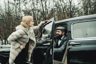 Sakallı adam ve kürk manto seksi kadın. Çift Romantik tarihte aşık. Seyahat ve iş gezisi ya da hiking hitch. Retro koleksiyonu araba ve otomatik mekanik sürücü tarafından onarın. Eskort kız güvenlik tarafından