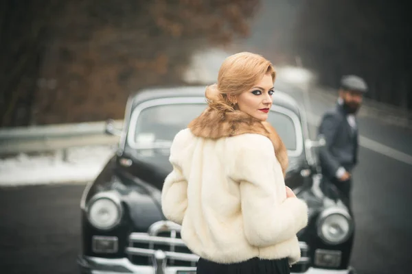 リムジン車ドライバーと毛皮のコートのセクシーな女性 恋のカップルとレトロなスタイルでリムジン車 — ストック写真