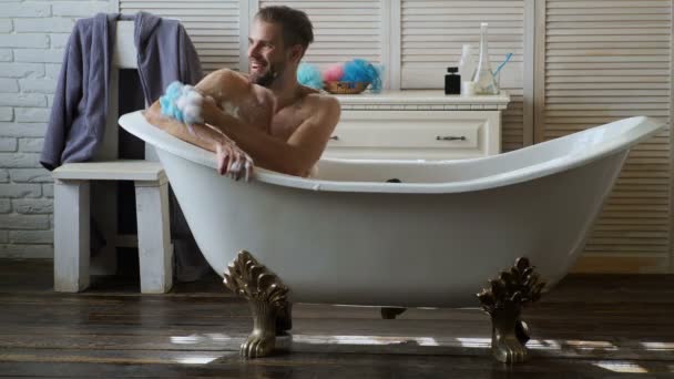 若いハンサムな男は浴槽でリラックスします Buthtub で風呂に入ってひげを持つ男 男性は 幸福とリラックスで高級バスタブで泡泡風呂で覆われています — ストック動画