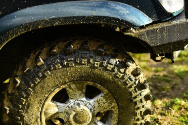 Tekerlek bir Suv ya da offroad araba çamurla kaplı. Kir, arabaya bir parçası kadar yakın. Aşırı, yarış ve 4 x 4 araç konsepti. Lastik ve lastik üzerinde kir