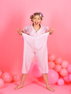 Pijama partisi balonlar pembe studio arka plan üzerinde. Mutlu çocuk giyim Hava balonlar altında. Küçük kız, diyet, punchy pastel, spor. Retro çocuk kız, pin up, fitness. Doğum günü dekor, çocukluk.
