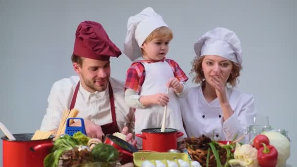家庭烹饪厨房食品的团结理念 一家人一起在厨房做饭 可爱的小男孩和他英俊的爸爸切蔬菜和微笑 而在厨房做饭在家 — 图库视频影像