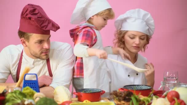 Roztomilý malý chlapec a jeho krásné rodiče se usmívají při vaření v kuchyni. Mladá rodina vaření v kuchyni. Šťastná rodina, společné vaření. Mladá rodina s mámou, táta dítě vaření. — Stock video