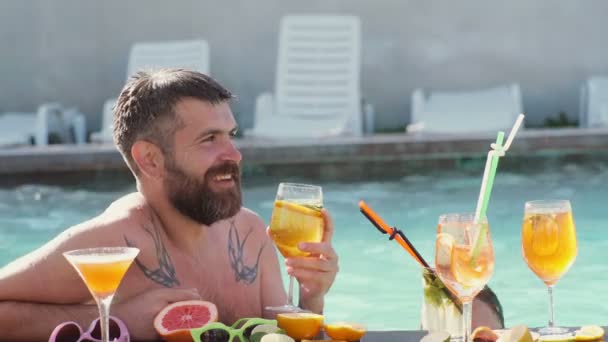 Disfrutando de la fiesta en la piscina con amigos. Feliz jóvenes amigos atractivos en gafas de sol se divierten en la piscina. Grupo de amigos juntos en la piscina de ocio . — Vídeos de Stock