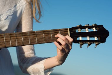 Kadın oyun gitar yaz güneşli gün plajda closeup.