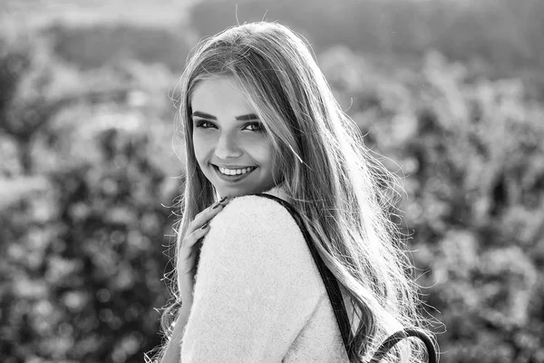 Pretty beautiful woman sexy model with blue eyes and long curly blond hair in coat smiles outdoors on sunny day on natural background — Stock Photo, Image