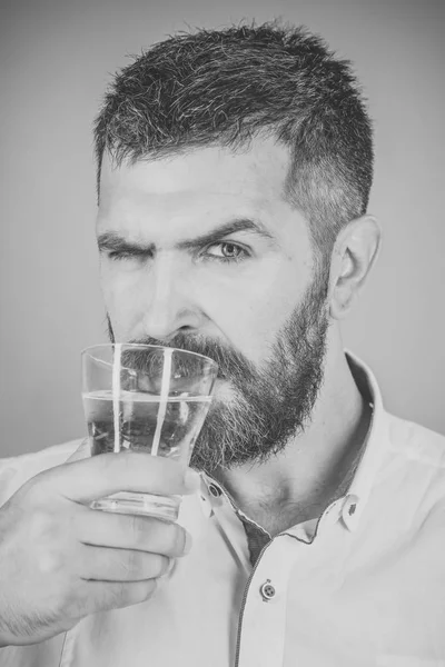 Mannen med skägg på allvarliga ansikte dricka vatten från glas — Stockfoto