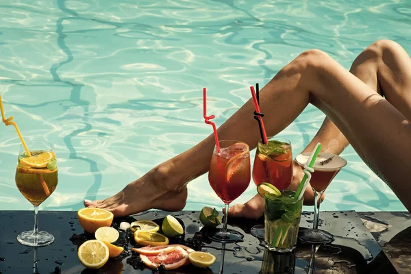 Cocktail en sexy been van het meisje in zwembad. — Stockfoto