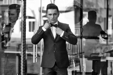 Cam kapı yakınındaki elbiseli genç adam