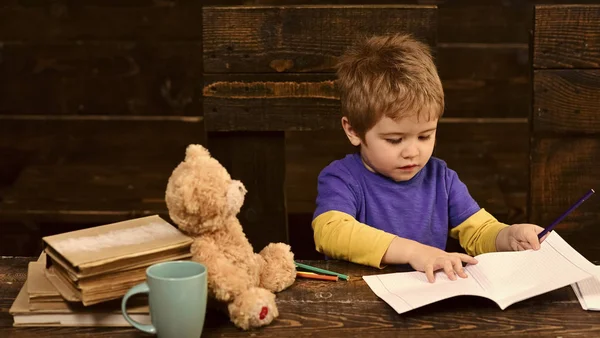 집중된 꼬마 카피북에서 작성입니다. 유치원 아이 책상에 앉아입니다. 유치원에서 글자를 학습 — 스톡 사진