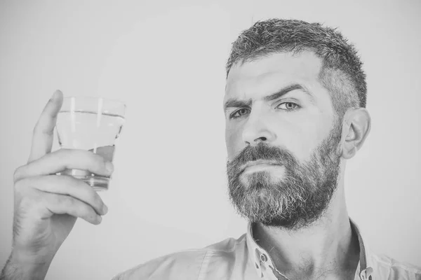 Man met baard op ernstige gezicht drinkwater uit glas — Stockfoto