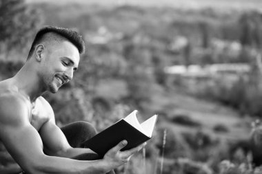 Kitap açık ile gülümseyen kaslı adam