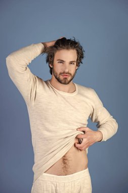 Mavi arka plan üzerinde sakallı uykulu adam.