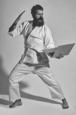 kimono dizüstü bilgisayar ile erkekte karate bağırarak sakallı