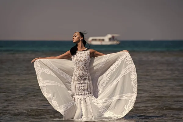 Ragazza sposa posa in abito da sposa con nave in mare — Foto Stock