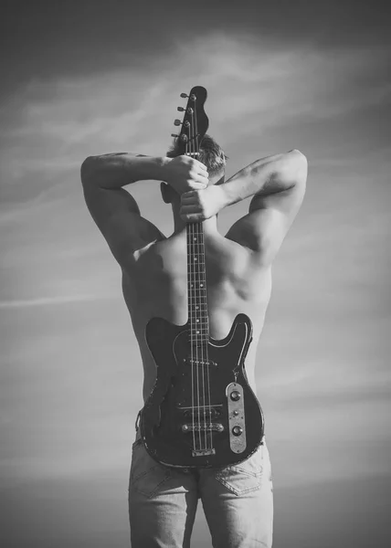 Sportsman with muscular back hold electric guitar — Stock Photo, Image