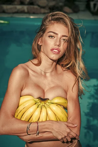 Verano piscina partido retrato de niña sosteniendo amarillo sabroso plátano exótico fruta, salud vegana — Foto de Stock