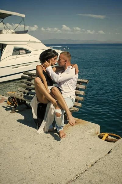Woman and man in fashionable clothes full of desire near luxury yacht. Couple in love on honeymoon. Honeymoon concept.