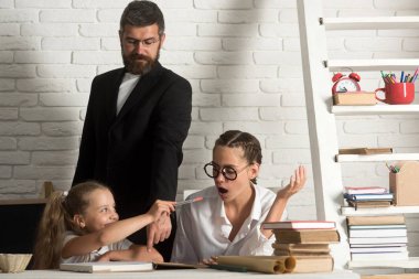 Geri okul ve evde eğitim için. geri okul kavramı gösterir akıllı kızlar okulda sakallı öğretmen ile çalışma.