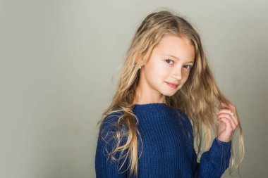 Manken, Güzellik, bak. Gri arka plan üzerinde güzel yüzü şık kızla. Kuaför, Cilt Bakımı, rahat tarzı, denim. Uzun saçlı küçük kız. Güzellik, çocuk moda ve sağlıklı saç.