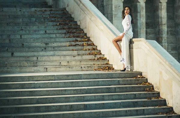 白いロングドレス結婚式 セクシーな花嫁のドレスの階段の上に立って前に大理石の階段でポーズでゴージャスな花嫁 — ストック写真