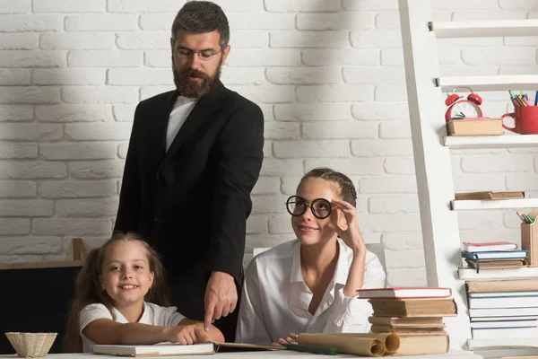 Lehrerin studiert Schulbücher im Unterricht mit Grundschulkindern. — Stockfoto