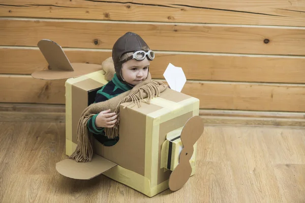 Little cute chłopiec gra z kartonu samolotu — Zdjęcie stockowe